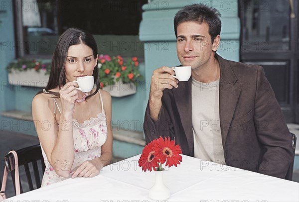 Hispanic couple drinking coffee at outdoor cafe