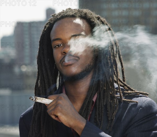 African man smoking hand-rolled cigarette