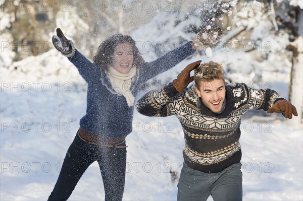 Caucasian couple playing in snow