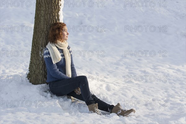 Caucasian woman sitting in snow