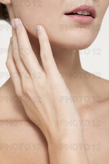 Nude Caucasian woman touching her jaw