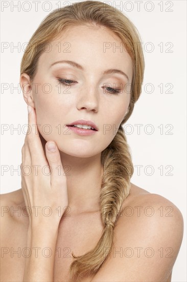 Nude Caucasian woman touching her jaw