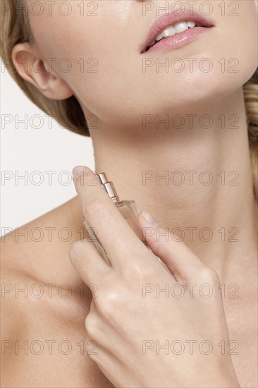 Caucasian woman spraying perfume