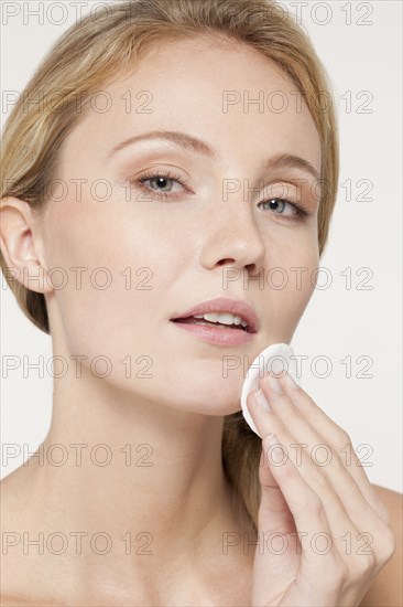 Caucasian woman applying makeup