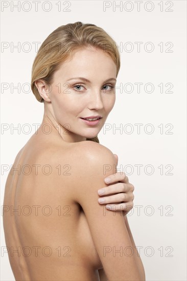 Nude Caucasian woman looking over shoulder