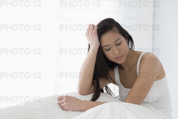 Mixed race woman sitting in bed