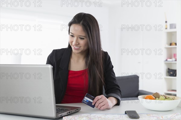 Mixed race businesswoman shopping online