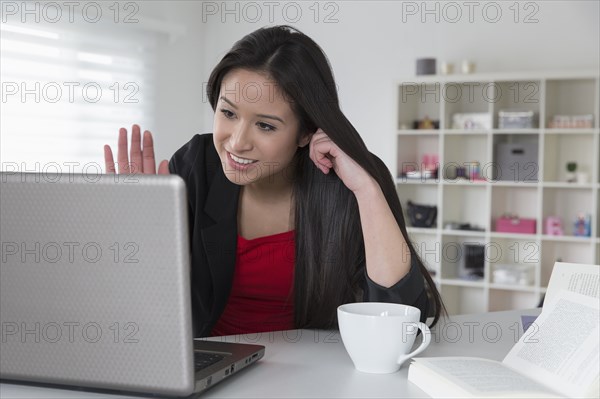 Mixed race businesswoman using laptop