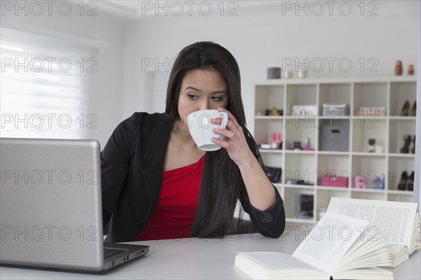 Mixed race businesswoman using laptop