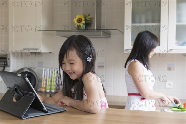 Asian mother and daughter in kitchen