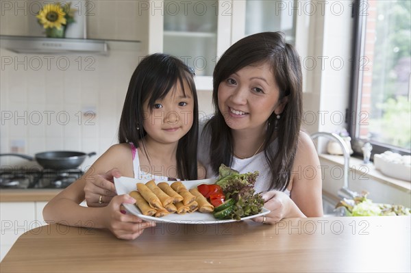 Asian mother and daughter cooking together