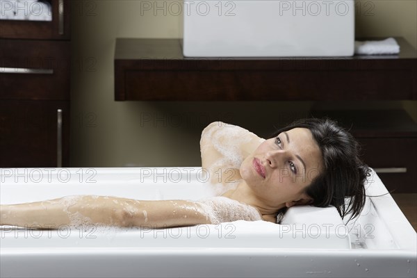 Caucasian woman relaxing in bubble bath