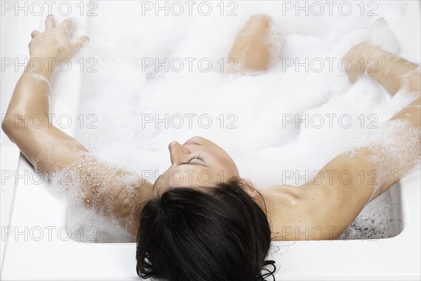 Caucasian woman relaxing in bubble bath