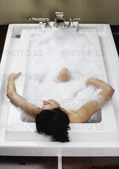 Caucasian woman relaxing in bubble bath