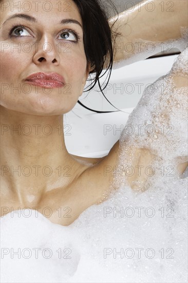 Caucasian woman relaxing in bubble bath