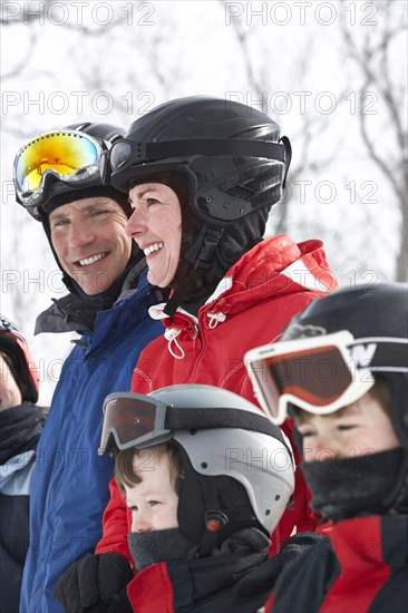 Caucasian family wearing ski gear in snow