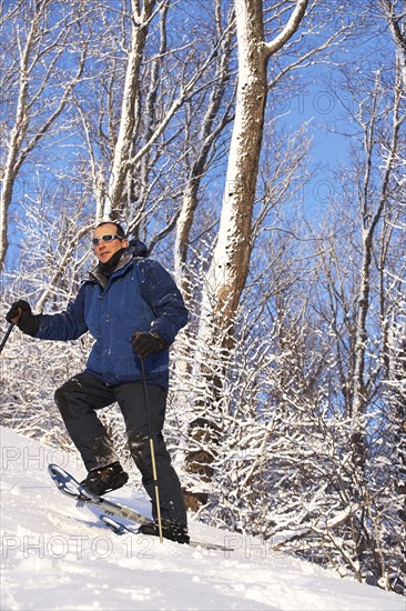 Caucasian man snowshoeing on slope