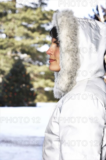 Caucasian woman wearing fur hood in snow