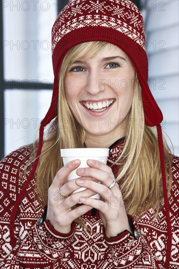 Caucasian woman in winter hat with cup of coffee