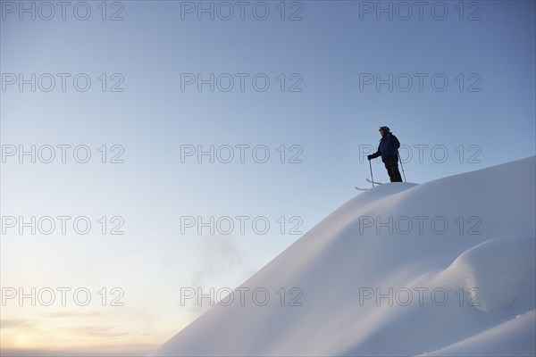 Caucasian skier standing on snowy hilltop