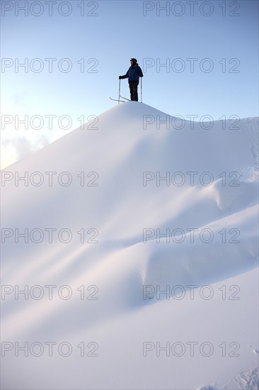 Caucasian skier standing on snowy hilltop