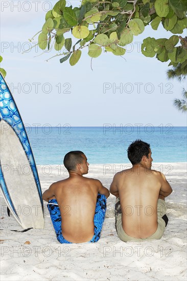 Surfers sitting together on beach