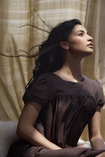 Hispanic woman's hair blowing in wind