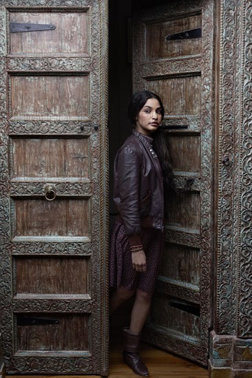 Hispanic woman standing in ornate doorway