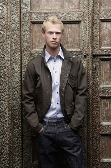 Caucasian man standing at ornate door