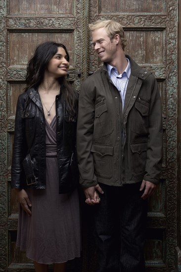 Couple holding hands in ornate doorway