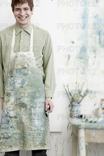 Caucasian artist smiling in studio