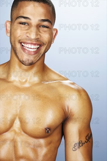 Bare chested mixed race man smiling