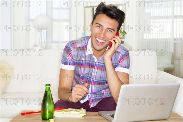 Mixed race teenager using laptop and cell phone