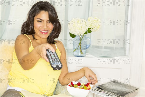 Hispanic woman holding remote control