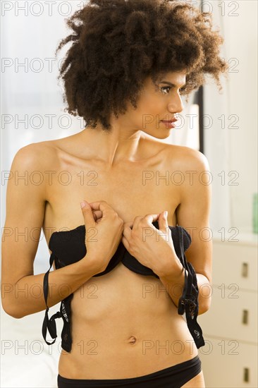 Mixed race woman getting dressed