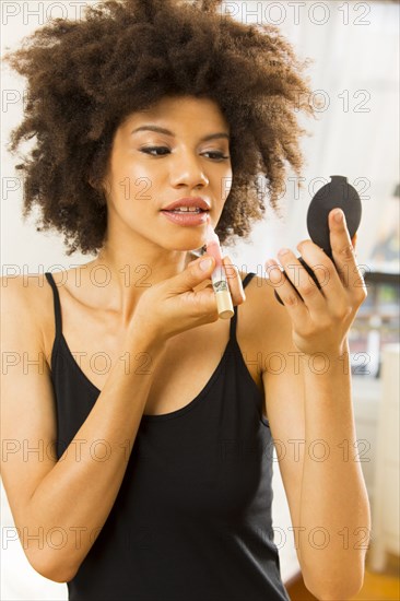 Mixed race woman applying makeup