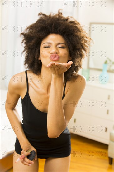 Mixed race woman blowing a kiss