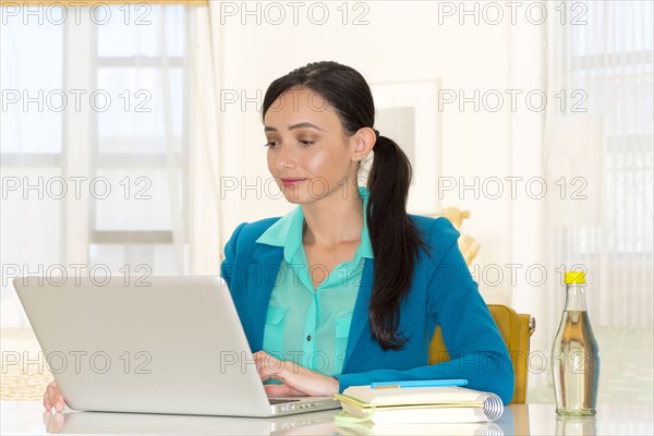 Mixed race businesswoman working at desk