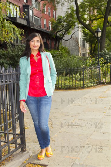 Mixed race woman smiling on urban sidewalk