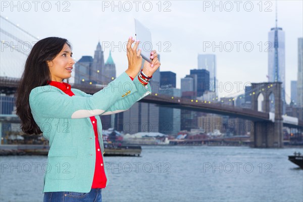 Mixed race woman taking pictures at waterfront
