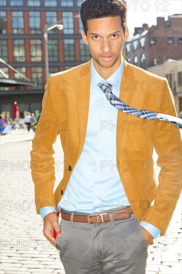 Mixed race businessman walking on city street