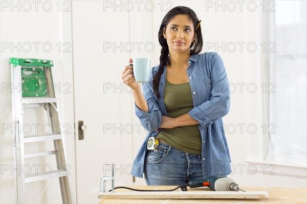 Mixed race contractor having cup of coffee in shop