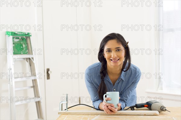 Mixed race contractor having cup of coffee in shop