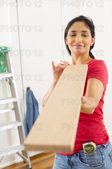 Mixed race woman examining plank of wood