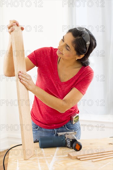 Mixed race woman examining plank of wood