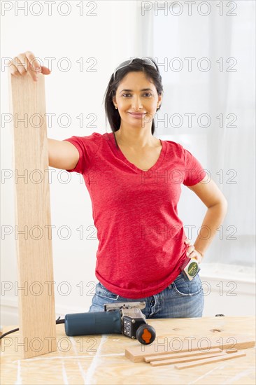 Mixed race woman holding plank of wood