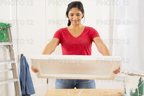 Mixed race woman examining window pane