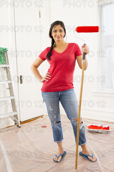 Mixed race woman painting room