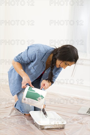 Mixed race woman painting room