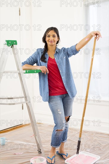 Mixed race woman painting room